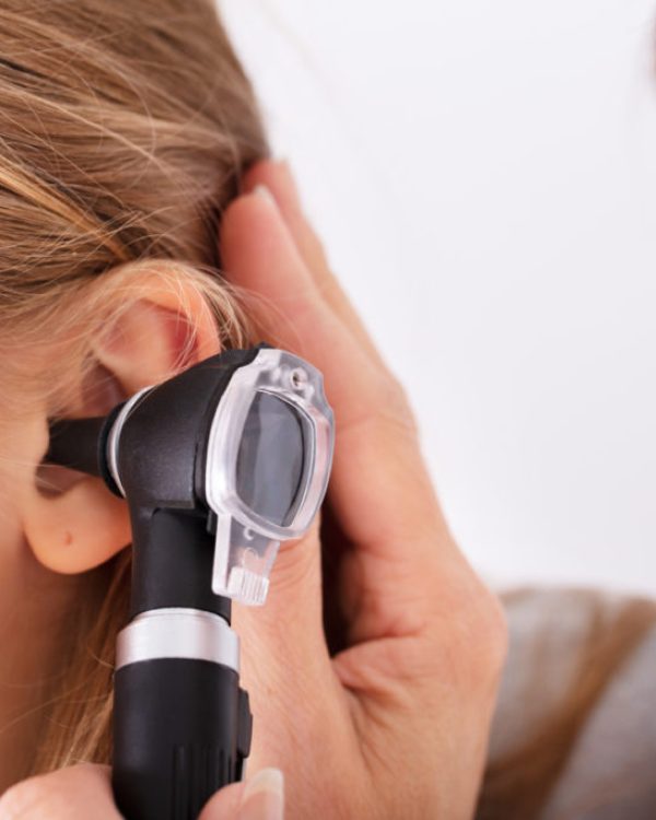 Close-up Of Doctor Checking Happy Girl's Ear With Otoscope